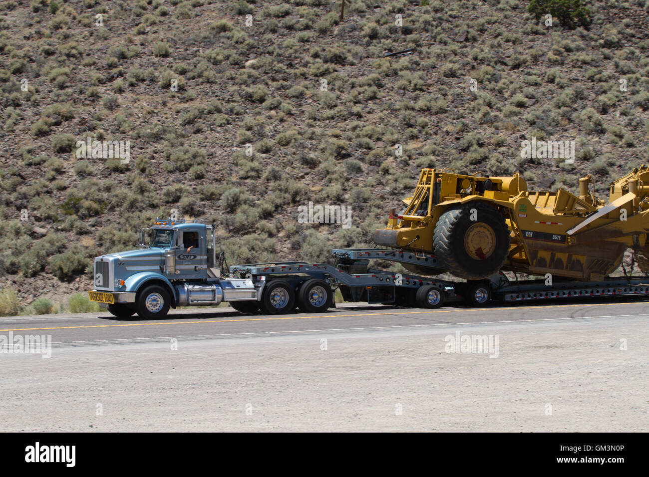 Large truck hauling an earth moving machine. USA Stock Photo
