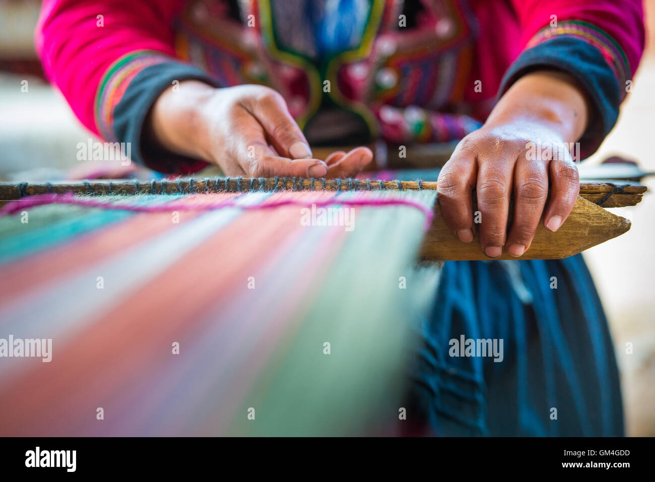 Peruvian weaver's hands crafting colorful wool traditional weaving Stock Photo