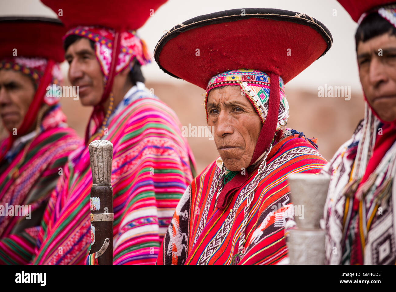 Indigenous town elders dressed in traditional weavings gather in front ...