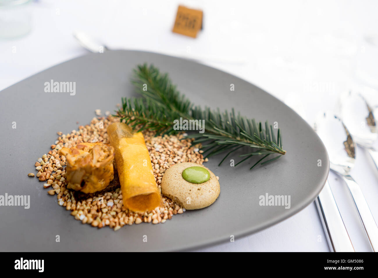 First course at the 'Langen Tafel der Genusshauptstadt Graz' with mushrooms and herbs on buckwheat on grey plate Stock Photo