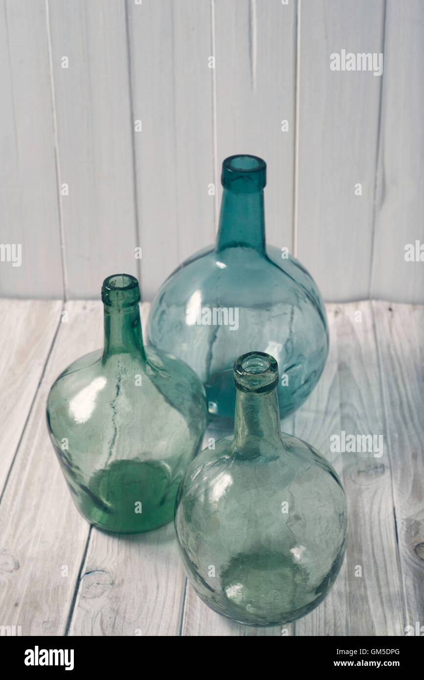 three bottles of green glass on a wooden background. vintage processing Stock Photo