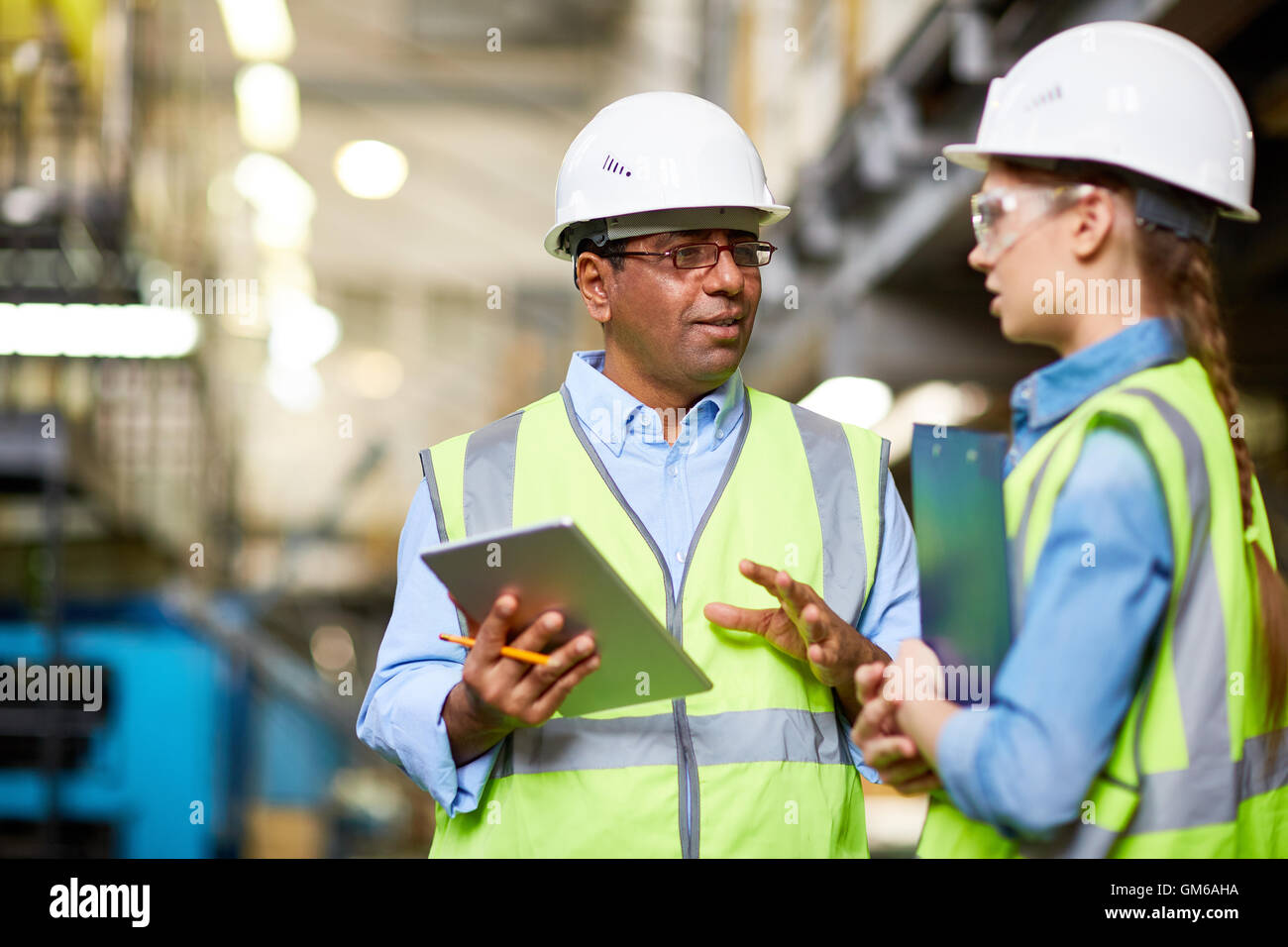 Two Engineer Computer Two engineers discussing work and using tablet pc Stock Photo - Alamy