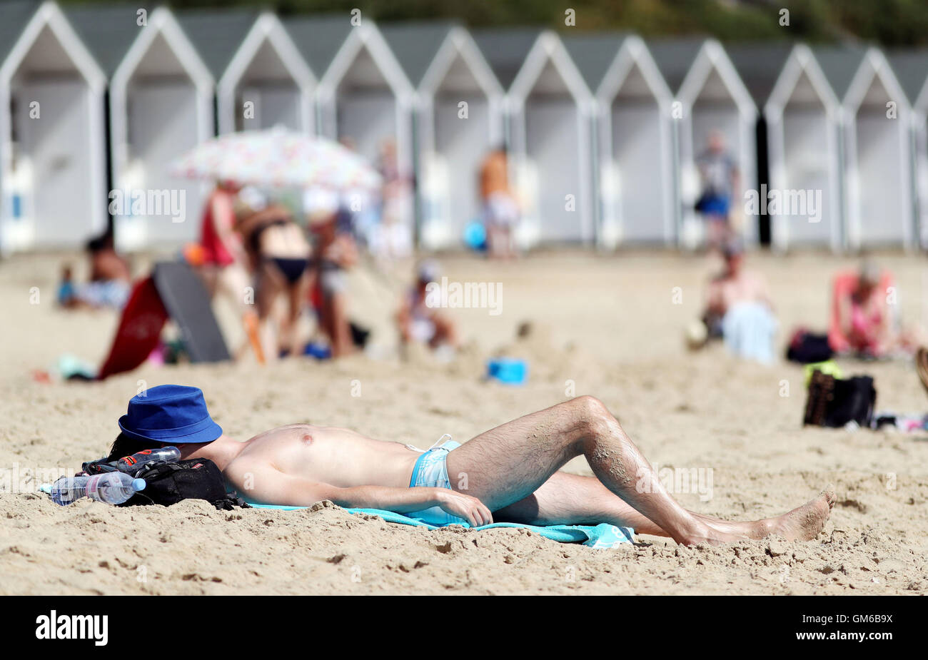 A man sunbathes on Branksome Chine Beach in Bournemouth, as a heatwave causes parts of the country to sizzle. Stock Photo