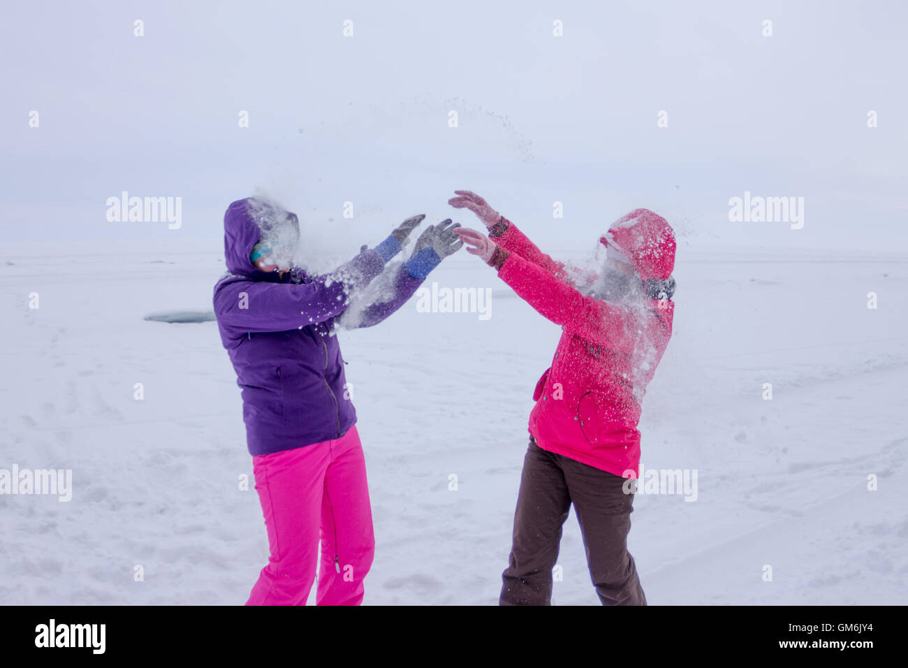 women play in the snow during snowfall on the ice of Lake Baikal Stock