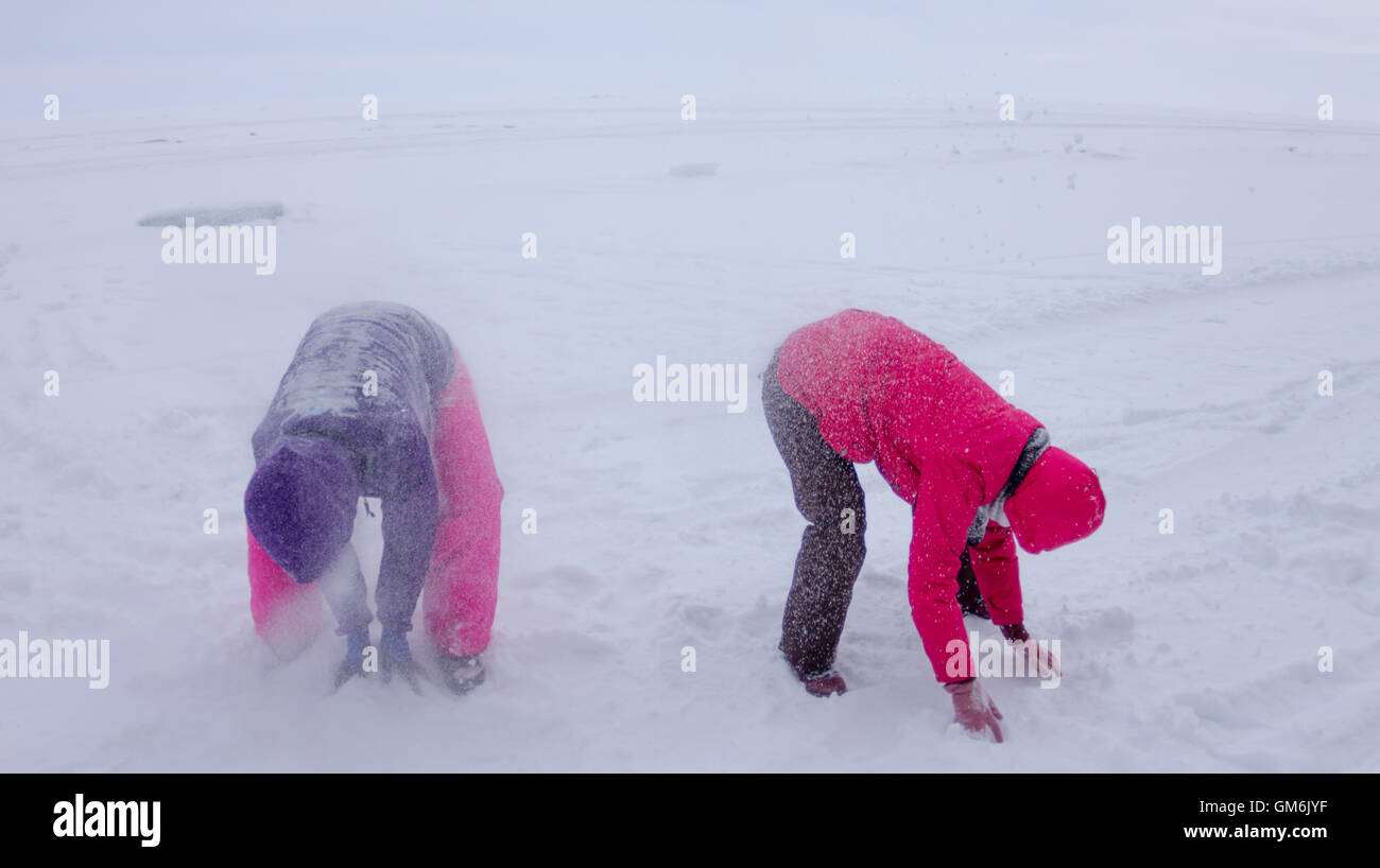 women play in the snow during snowfall on the ice of Lake Baikal Stock
