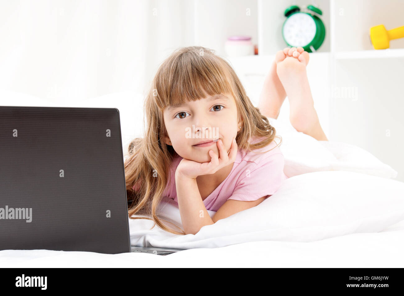 Girl with laptop on bed Stock Photo