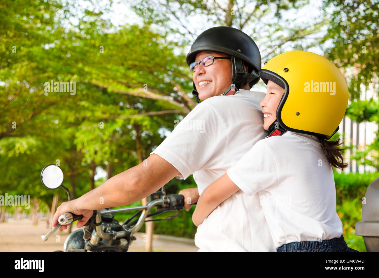 Father and daughter traveling on motorcycle Stock Photo
