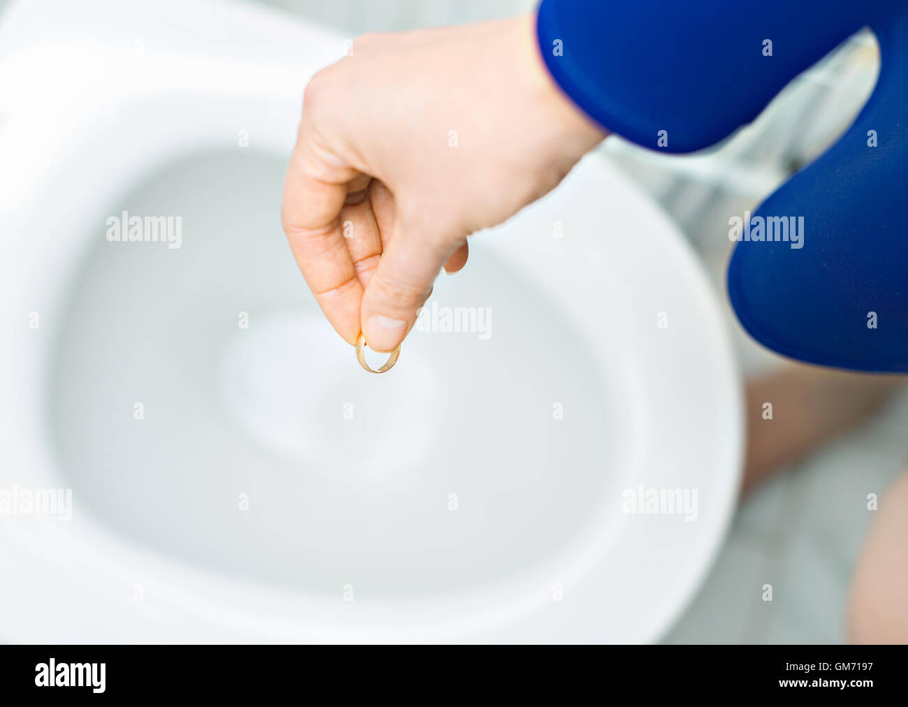 Divorce concept. Woman throwing her wedding ring in the toilet. Stock Photo