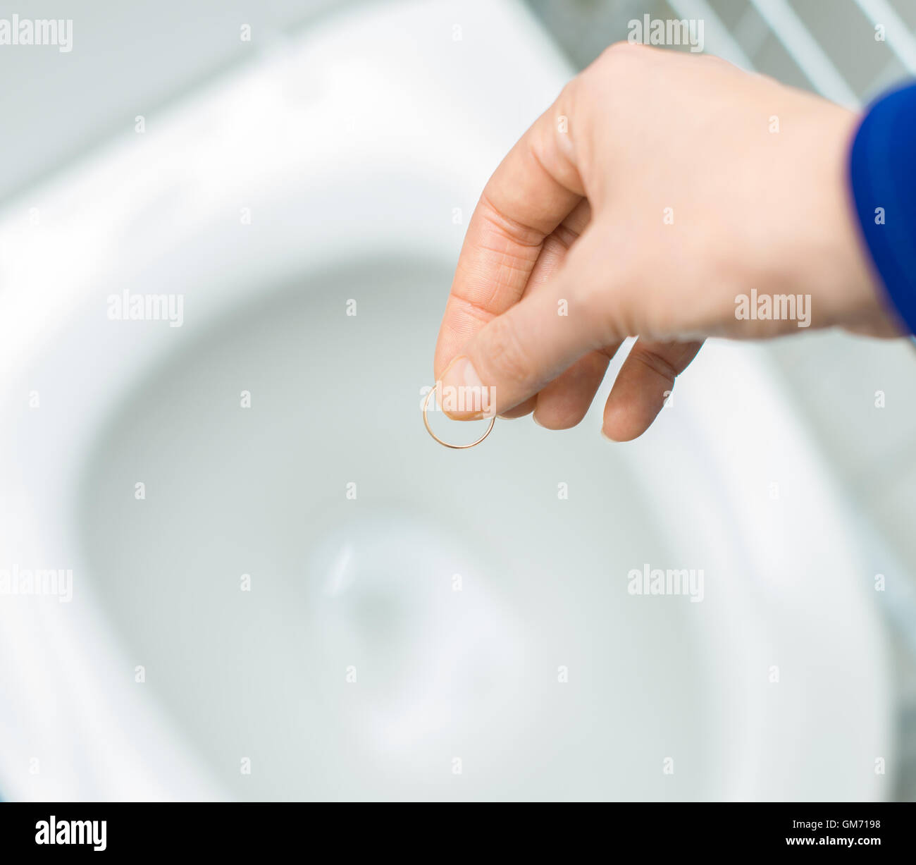 Divorce concept. Woman throwing her wedding ring in the toilet Stock