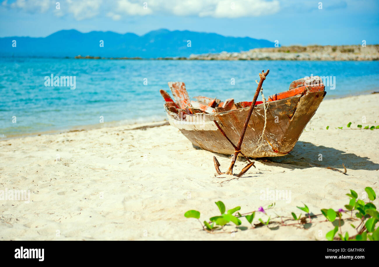 Old fisherman boat with anchor on the beach Stock Photo - Alamy