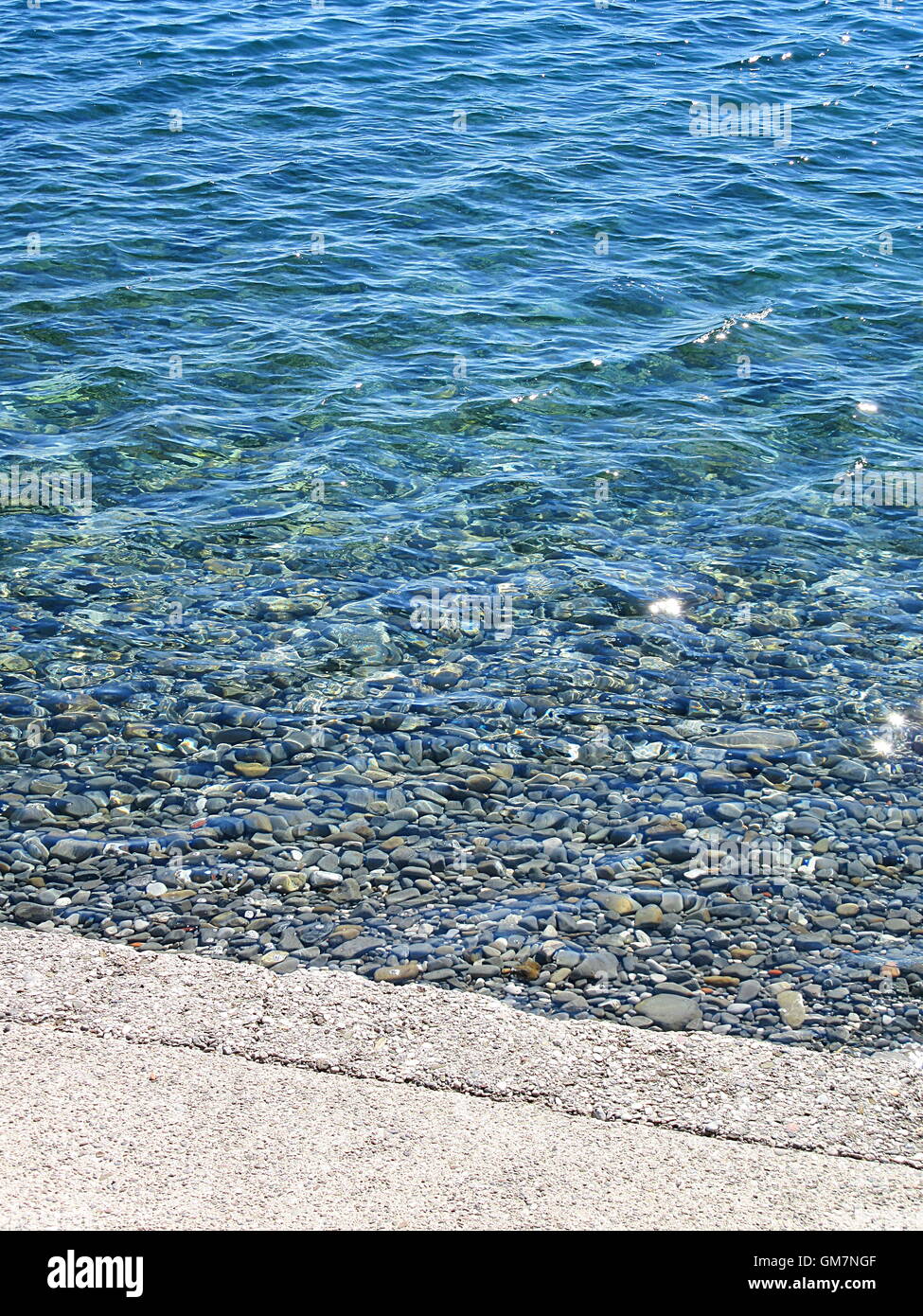 Full frame shot of blue sea and gravel shore beach Stock Photo