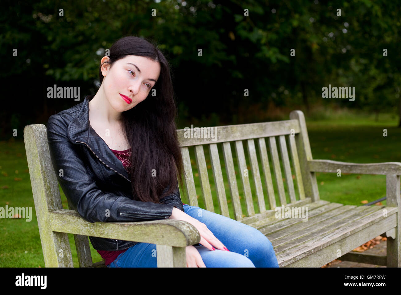 sad girl sitting in the park Stock Photo