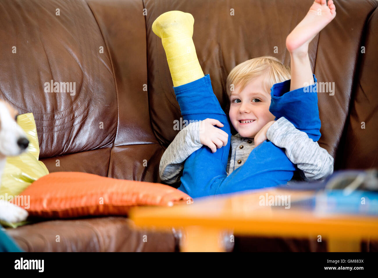 Boy with broken leg in cast sitting on couch Stock Photo Alamy