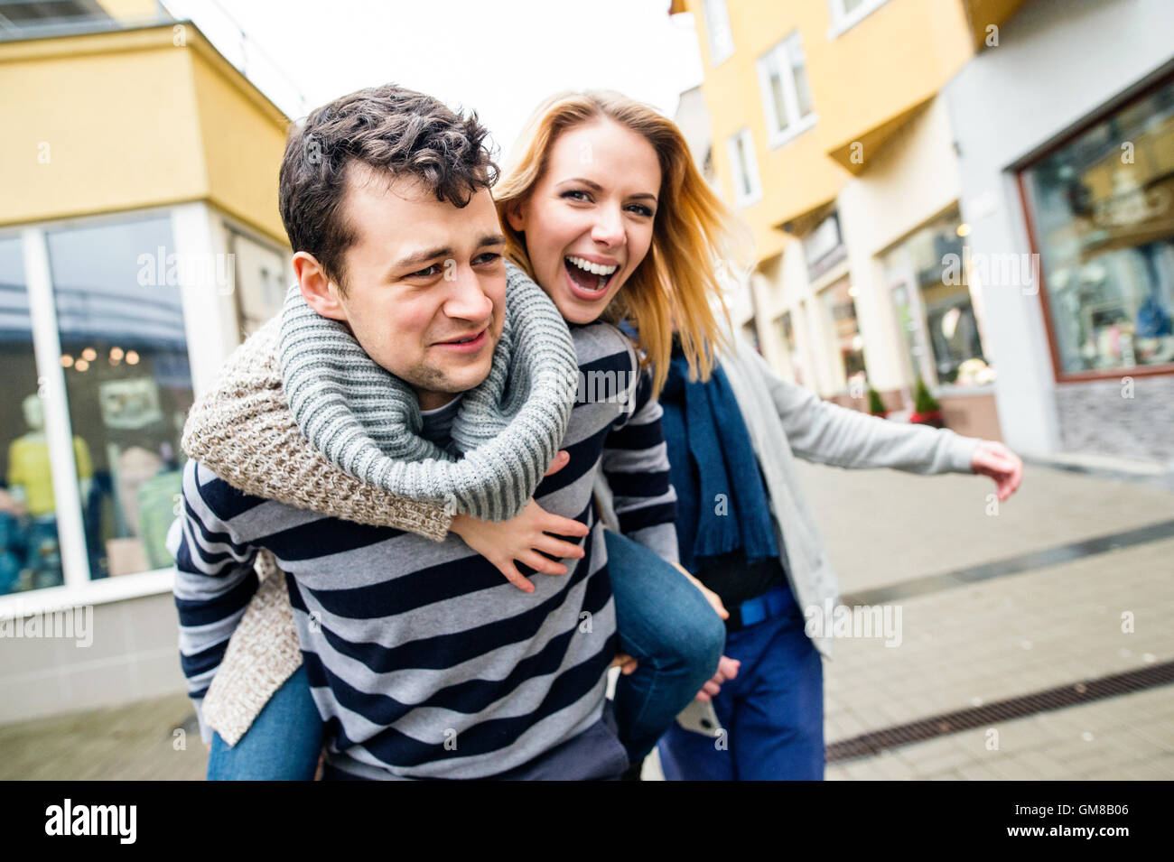 Young couple in love in town having fun, laughing Stock Photo