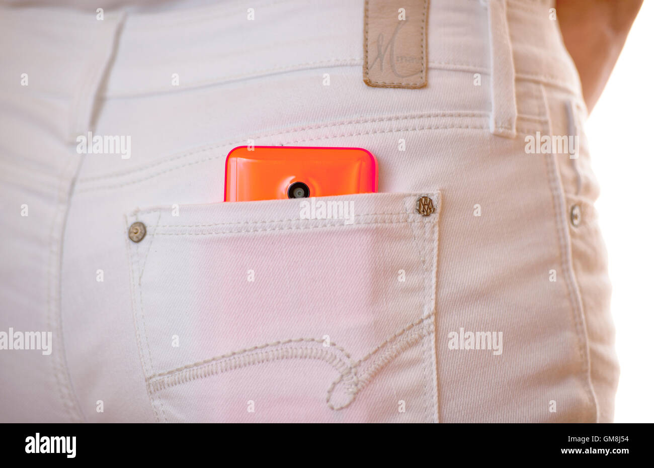 Smartphone stored in the back pocket of a girls white jeans Stock Photo