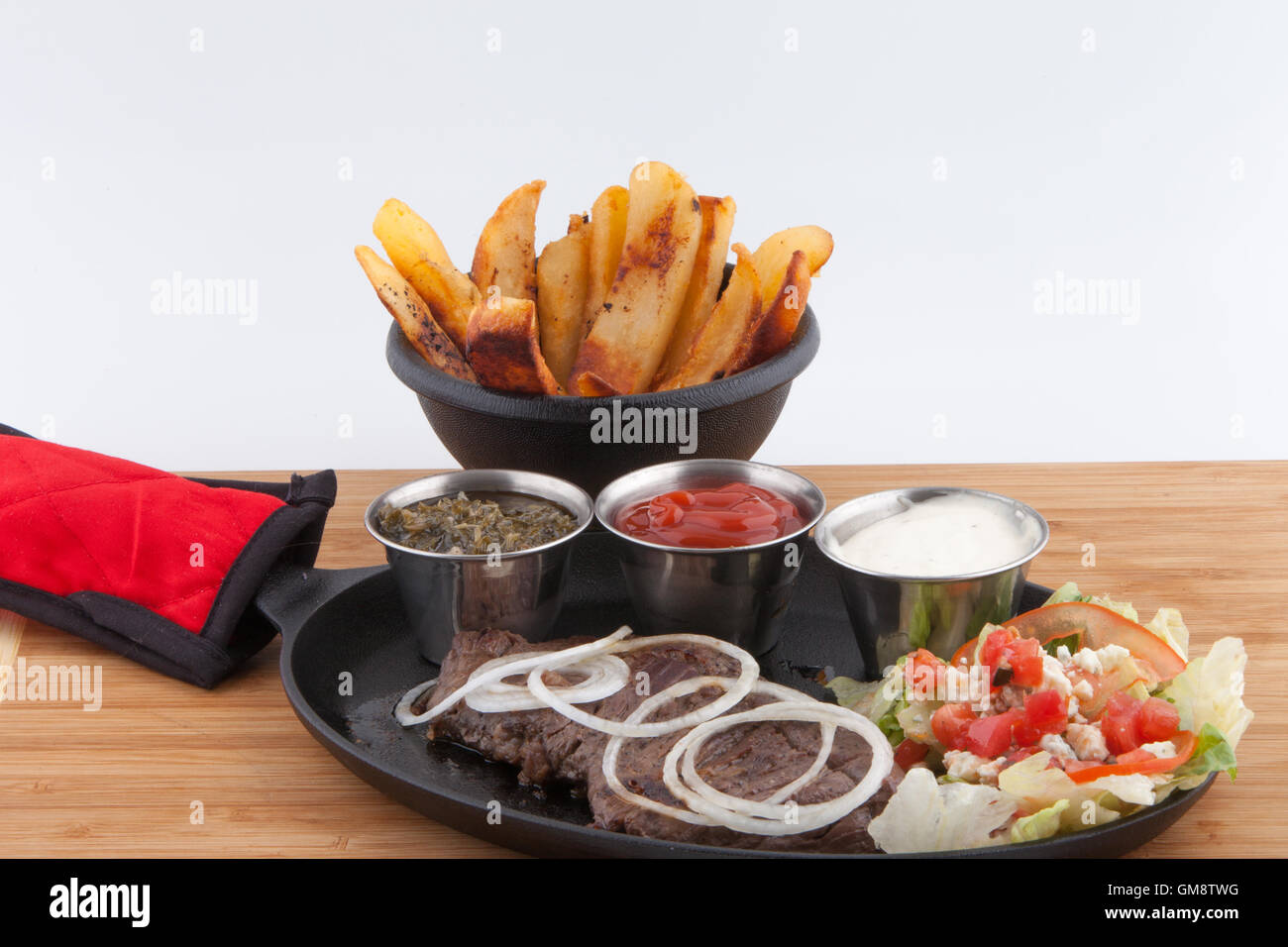 Flank steak,French Fries fresh garnish sauces Ketchup catsup table