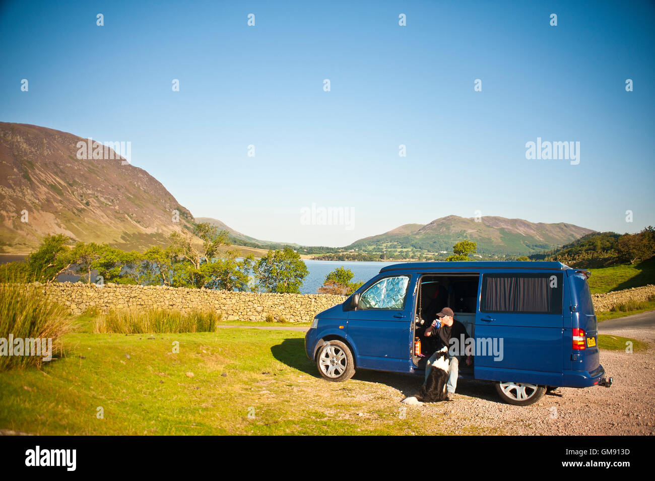 man & dog in van next to Crummock water in cumbria lake district, england Stock Photo
