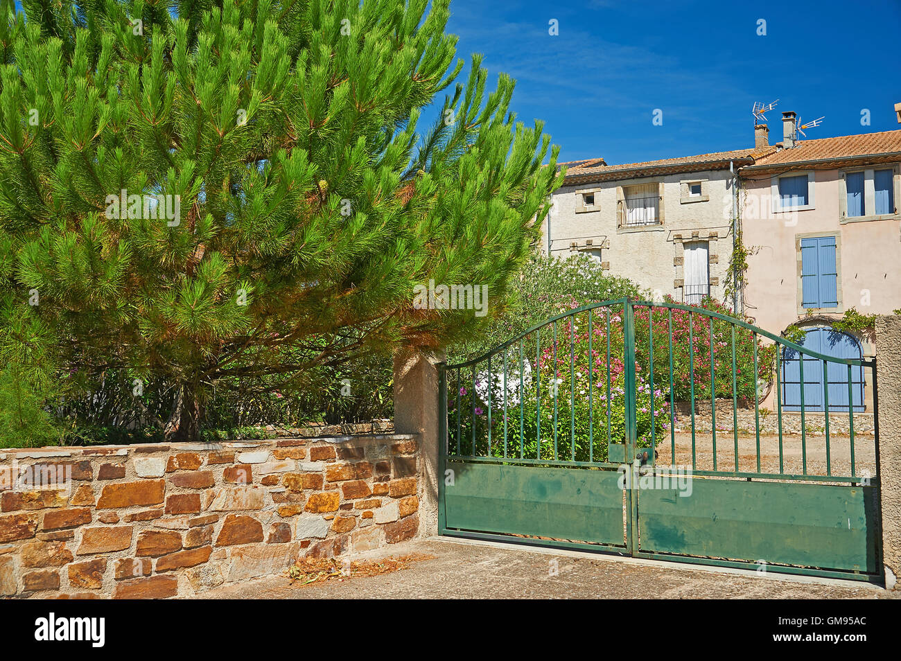 French houses with green gates at the end of the driveway Stock Photo