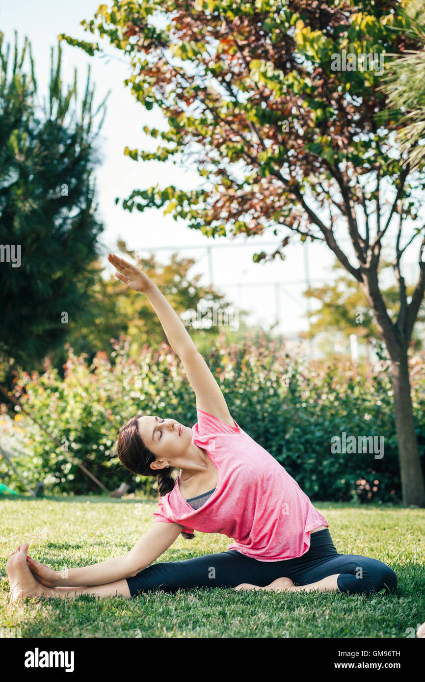 Young woman doing yoga in the park Stock Photo - Alamy