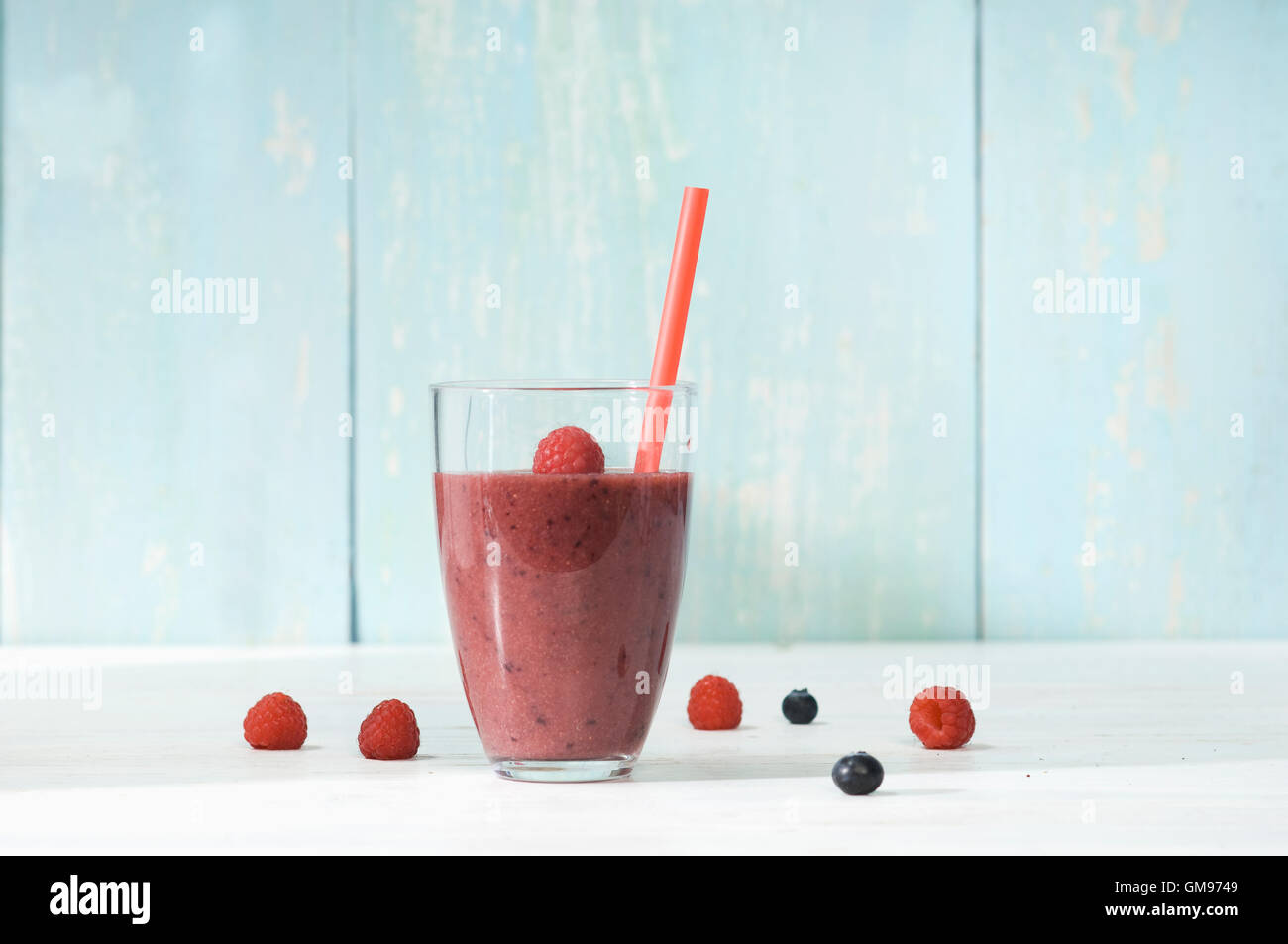 Raspberry blueberry smoothie in glass with drinking straw Stock Photo ...