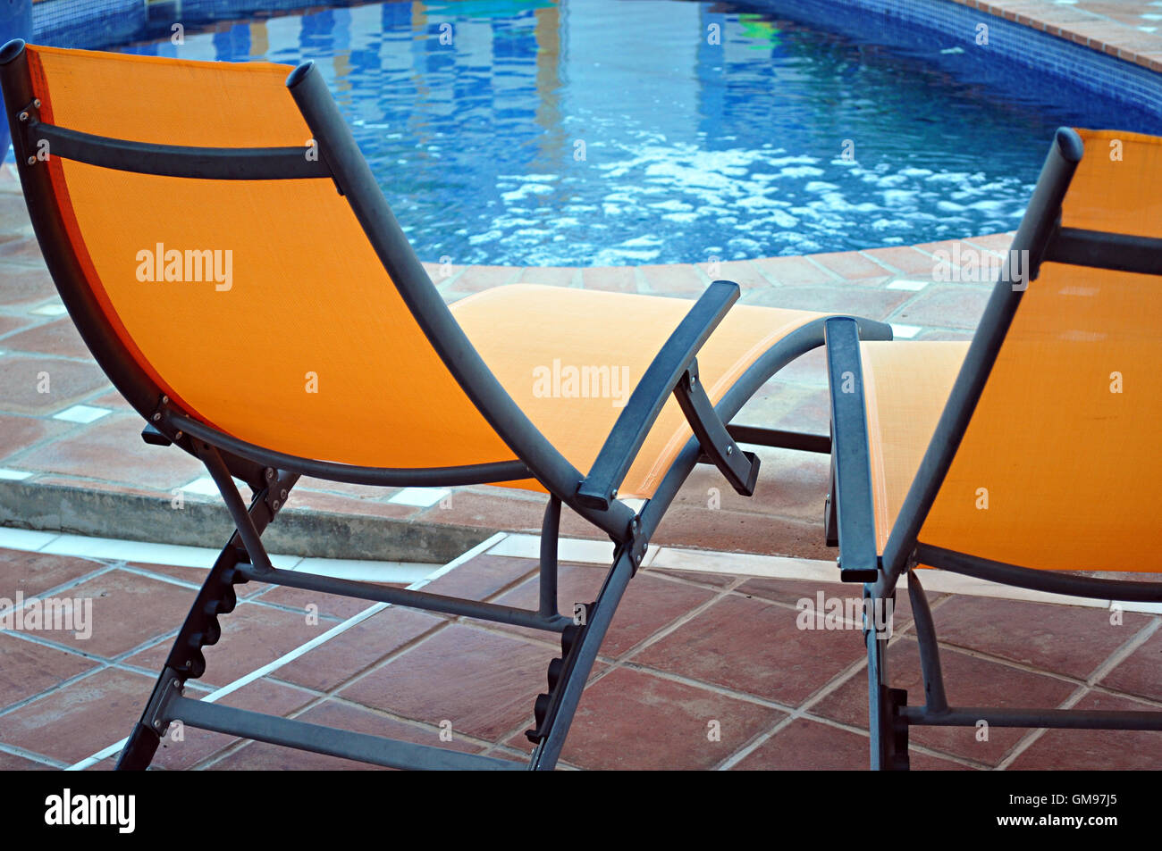 two chaise lounges poolside Stock Photo Alamy