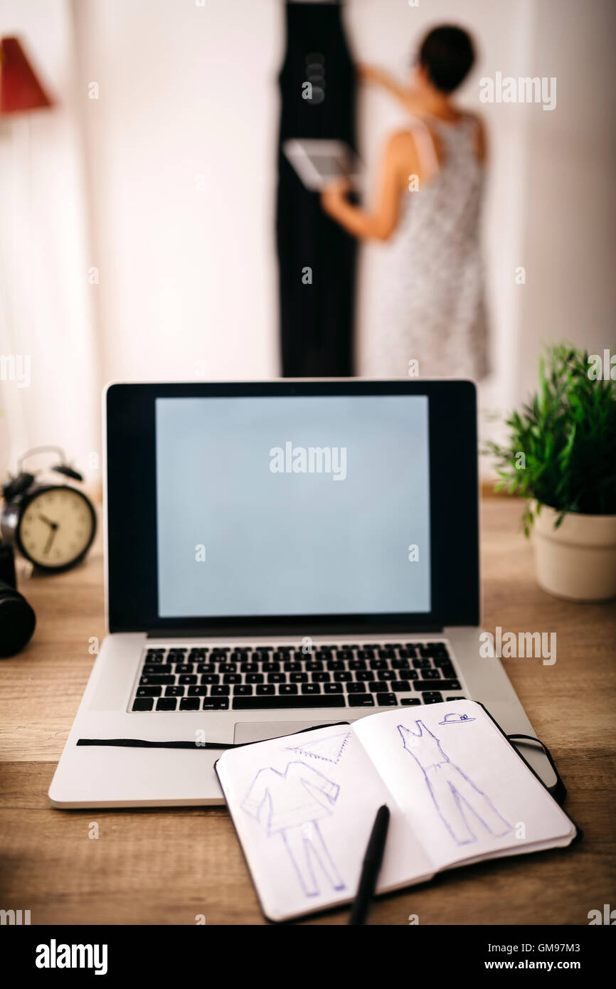Laptop and sketchbook on desk with woman in background Stock Photo Alamy