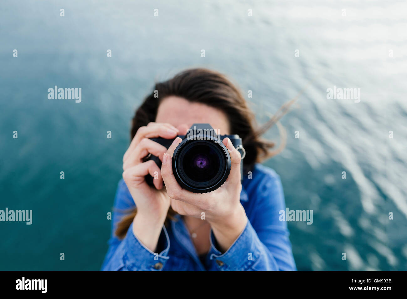 Young woman at the waterfront taking a picture Stock Photo - Alamy