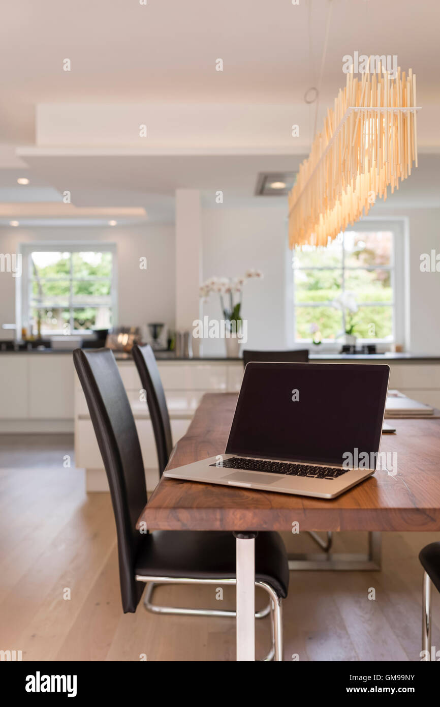 Modern dining area with open plan kitchen in the background Stock Photo ...