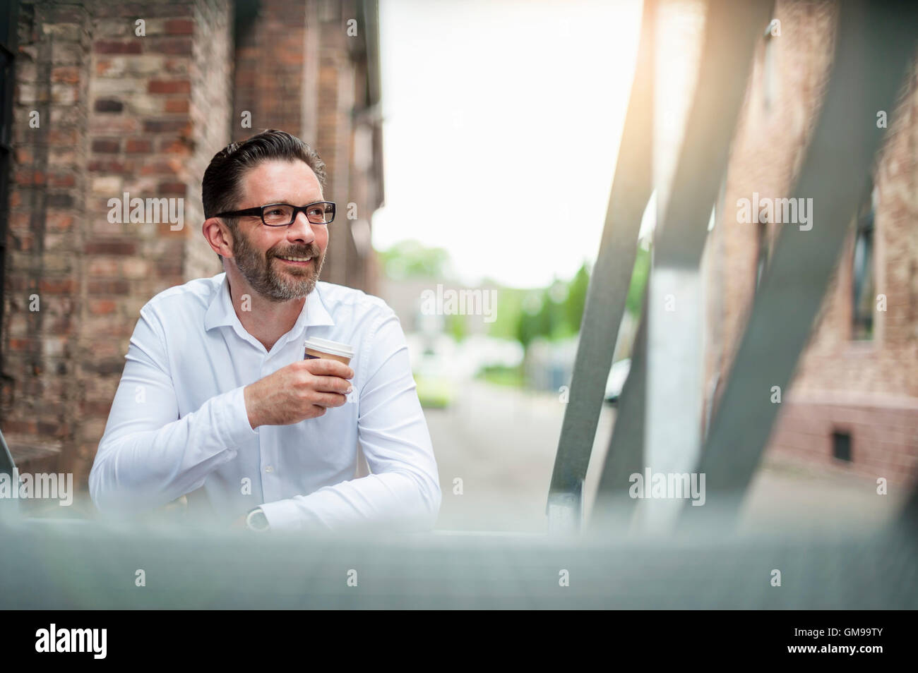Smiling businessman with coffee to go Stock Photo
