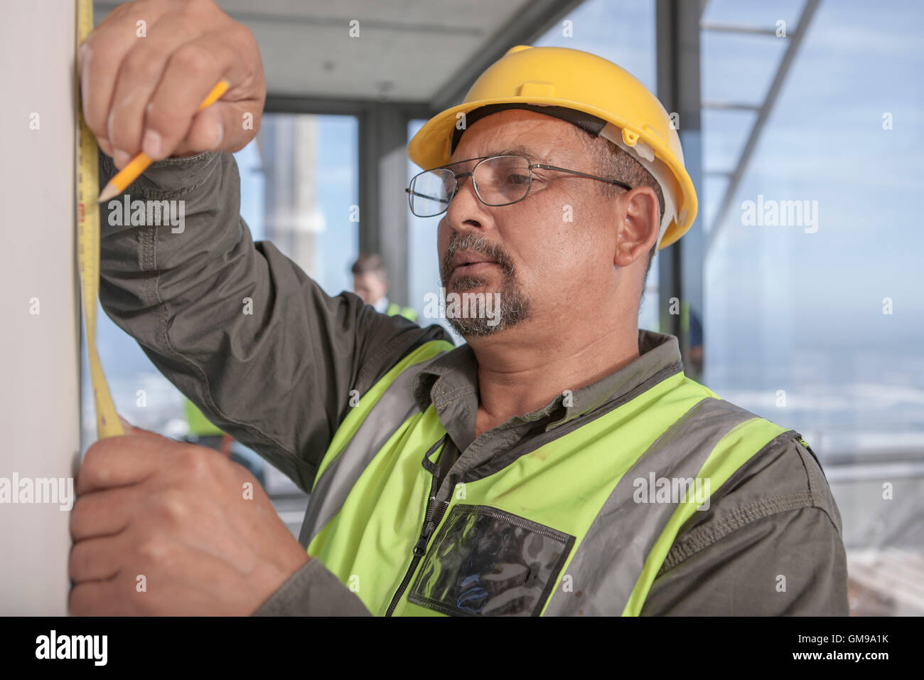 Construction worker measuring on construction site Stock Photo Alamy