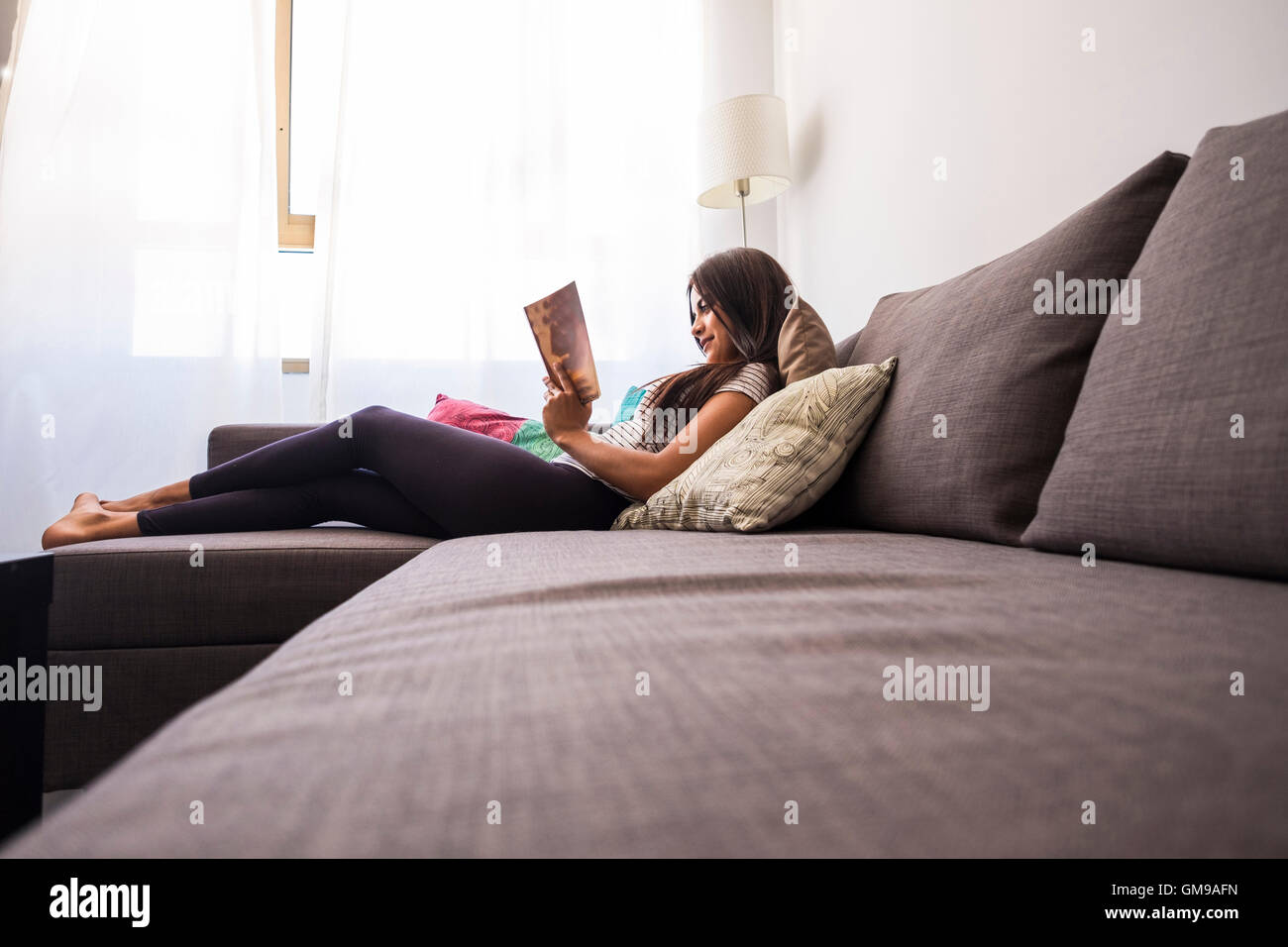 Barefoot girl lying on couch hi-res stock photography and images - Alamy