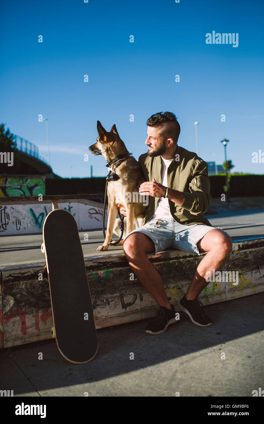 Skateboarder with his dog in a skatepark Stock Photo