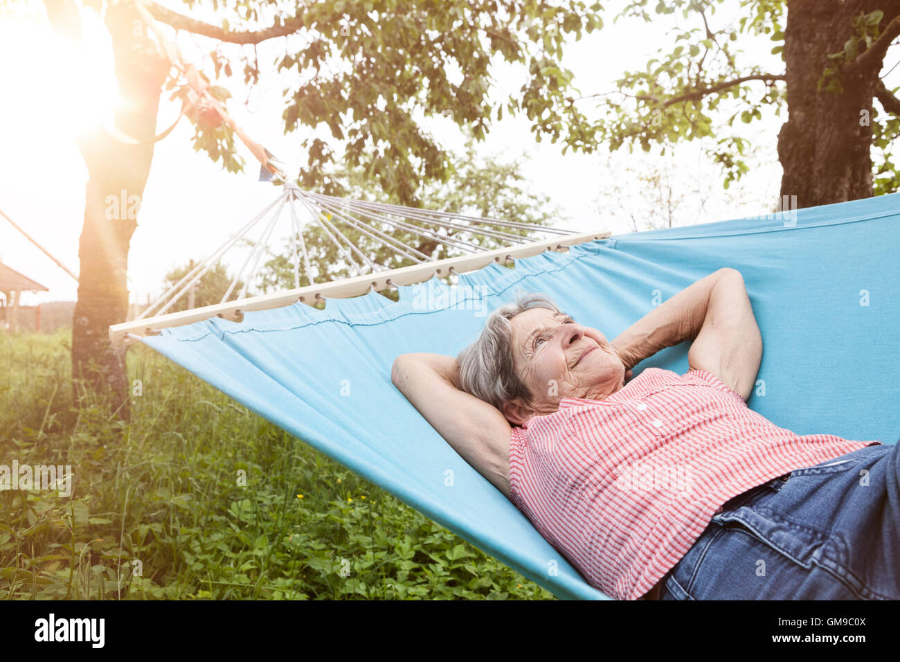 Senior woman relaxing in hammock Stock Photo - Alamy