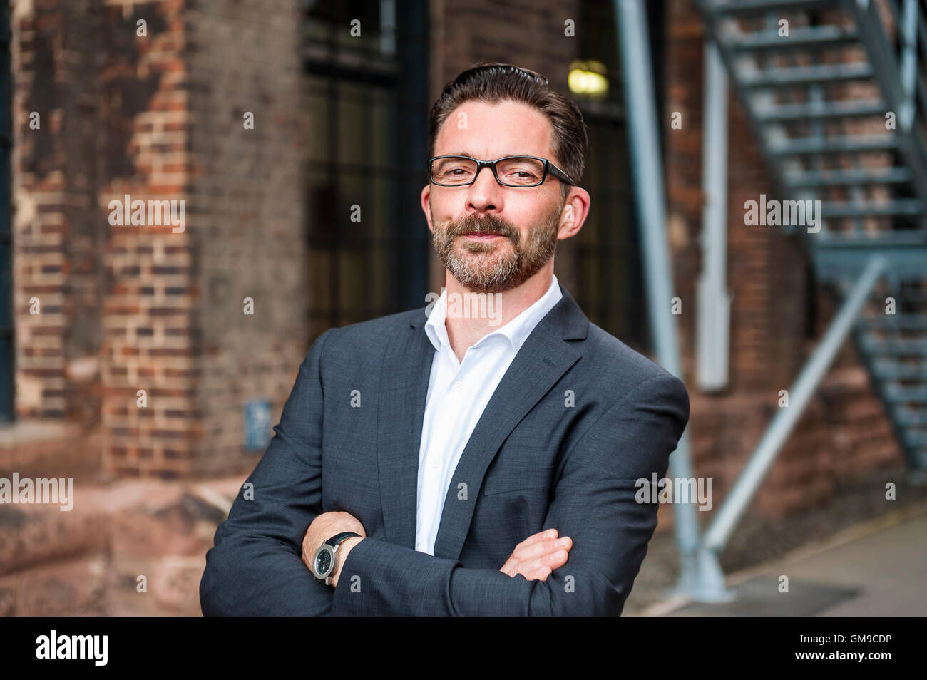 Portrait of smiling businessman with arms crossed Stock Photo - Alamy
