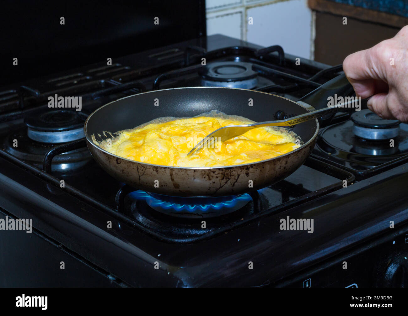 Scrambled eggs being cooked in pan over gas flame Stock Photo Alamy