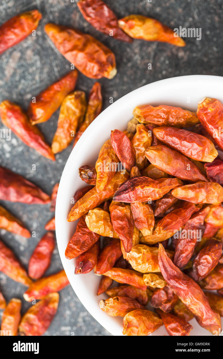 Dried mini chili peppers in bowl on kitchen table. Top view Stock Photo