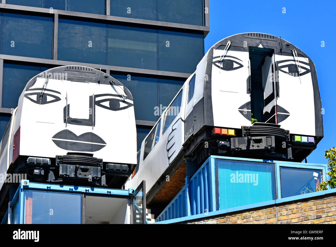 'Village Underground' recycled tube train carriages used as affordable artists studios perched on old shipping containers Shoreditch London England UK Stock Photo