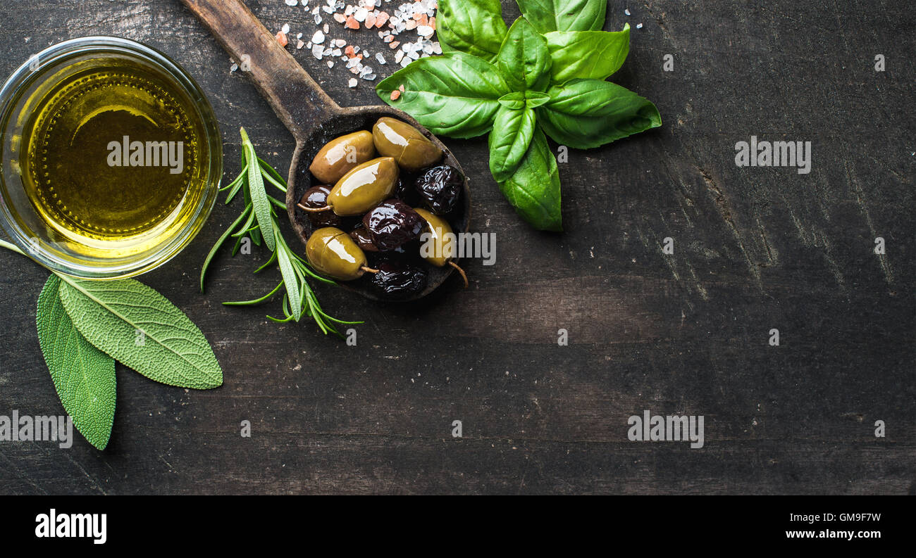 Green and black Mediterranean olives in old cooking spoon Stock Photo