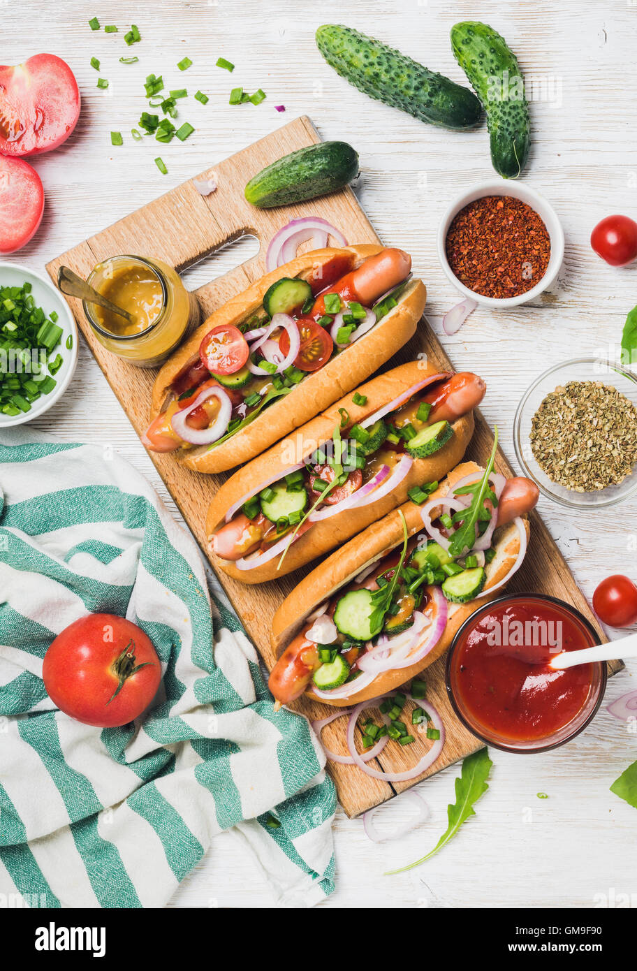Homemade hotdogs with fresh vegetables and spices over white