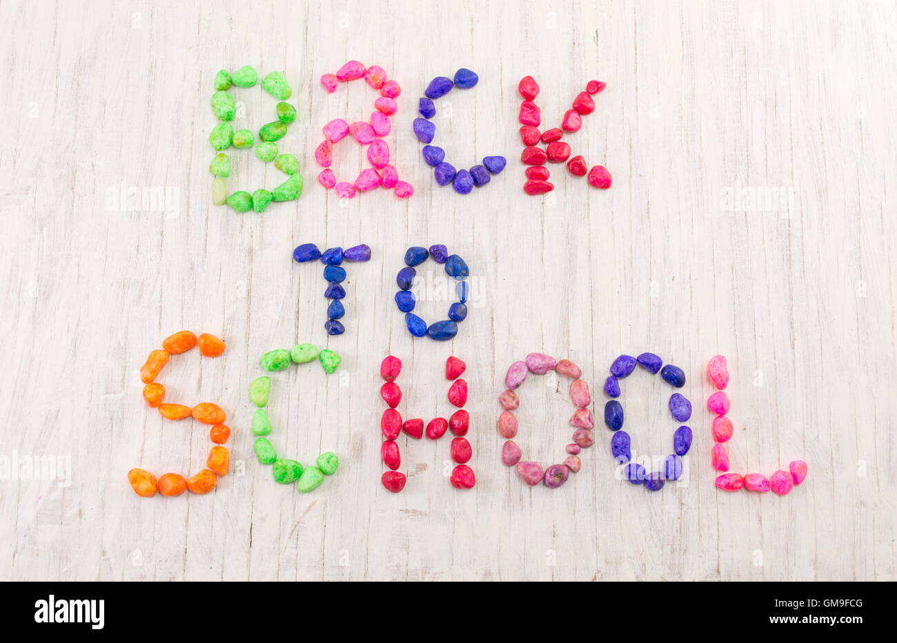 Back to school written with colorful stones on wooden background Stock Photo