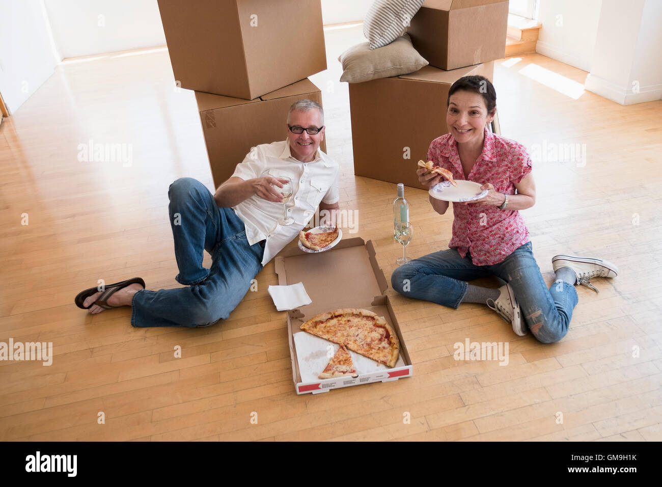 Couple eating pizza in new apartment Stock Photo