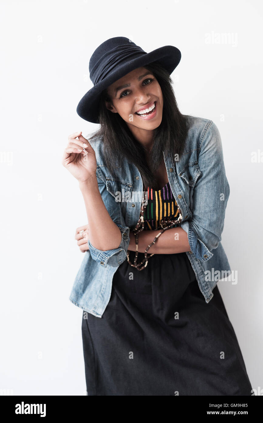 Studio portrait of mid adult woman in hat and denim jacket Stock Photo