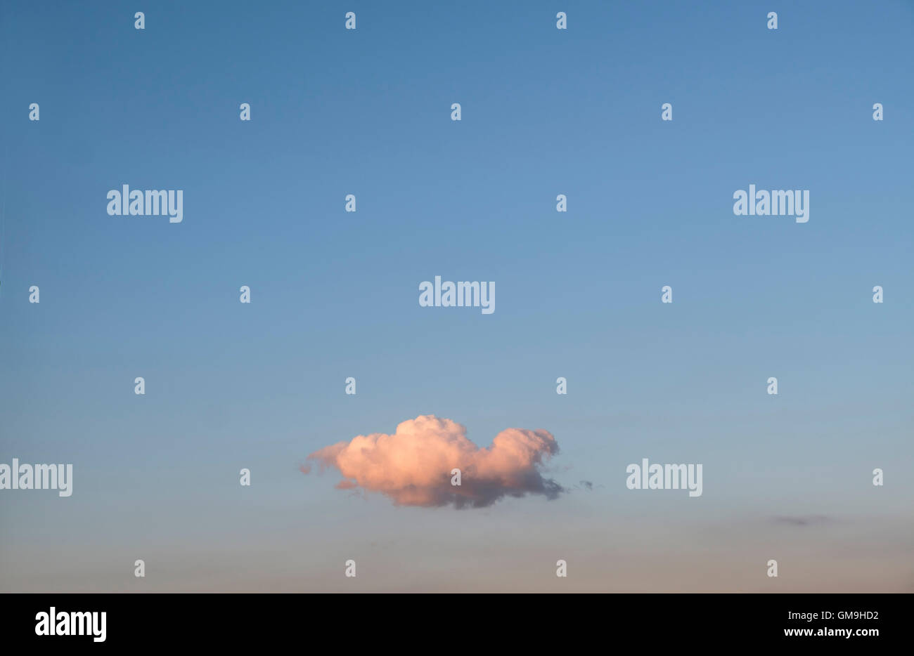 Single cloud on blue sky at sunset Stock Photo