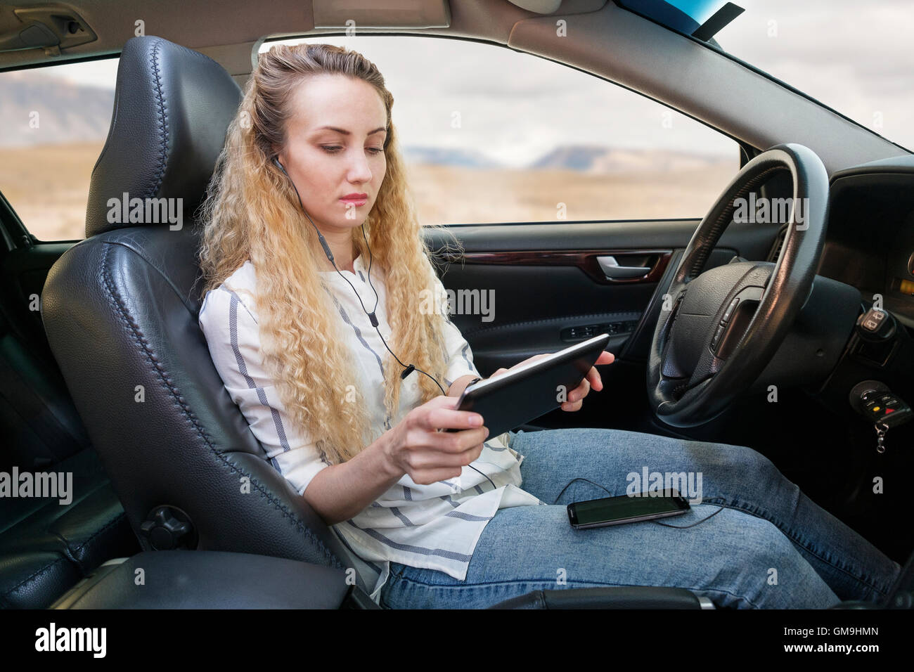 Woman sitting in car and using tablet Stock Photo