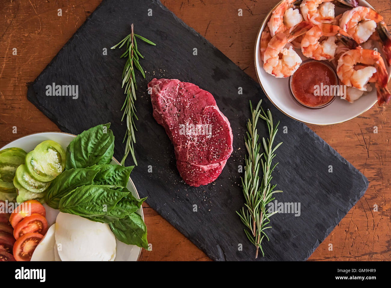 Steak between caprese salad and shrimps Stock Photo