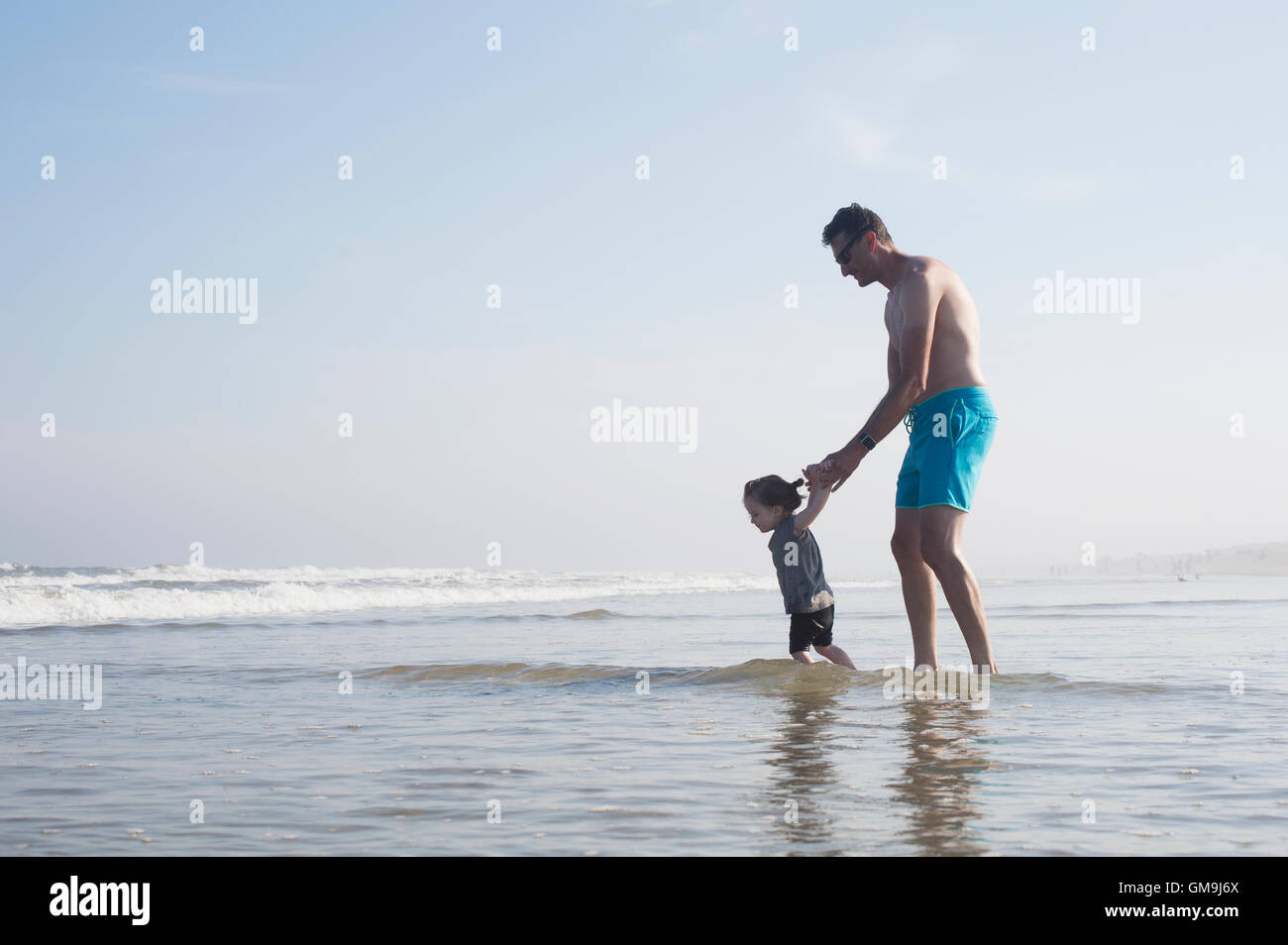 Father with daughter (18-23 months) wading in sea Stock Photo