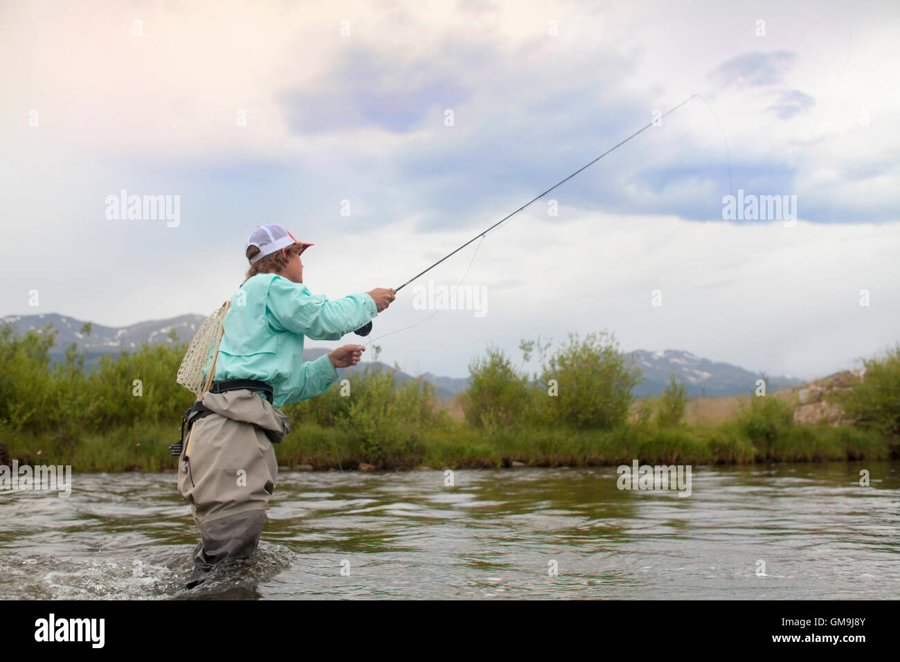 Colorado, Mid adult man wading and fishing in river Stock Photo