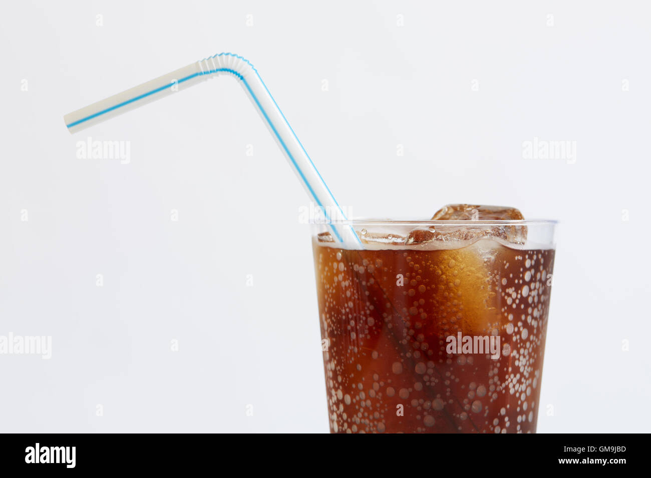 Studio shot of cold drink with ice cubes and plastic straw on white background Stock Photo