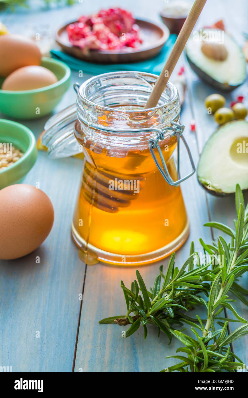 Jar of honey with dipper and fresh herbs Stock Photo Alamy