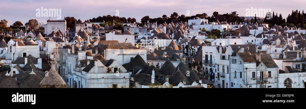 Italy, Apulia, Alberobello, Old town panorama of old trulli houses at sunset Stock Photo